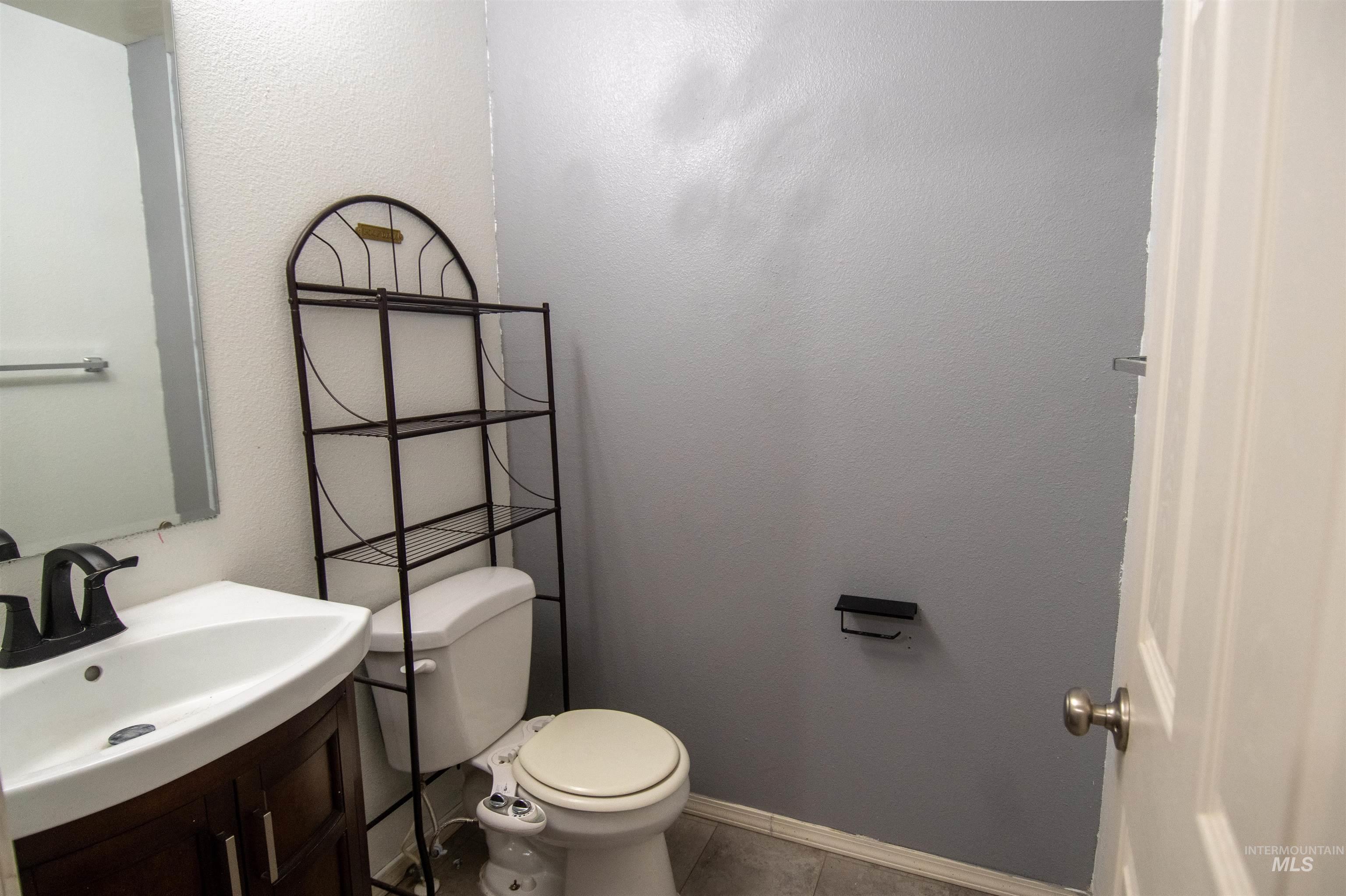 880 Southwest Independence Mountain Home, ID 83647 - Photo 10 of 50 Half bathroom featuring vanity, a textured wall, and tile patterned flooring