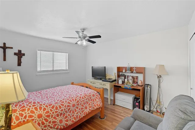 a bedroom with a bed wooden floor and a flat screen tv