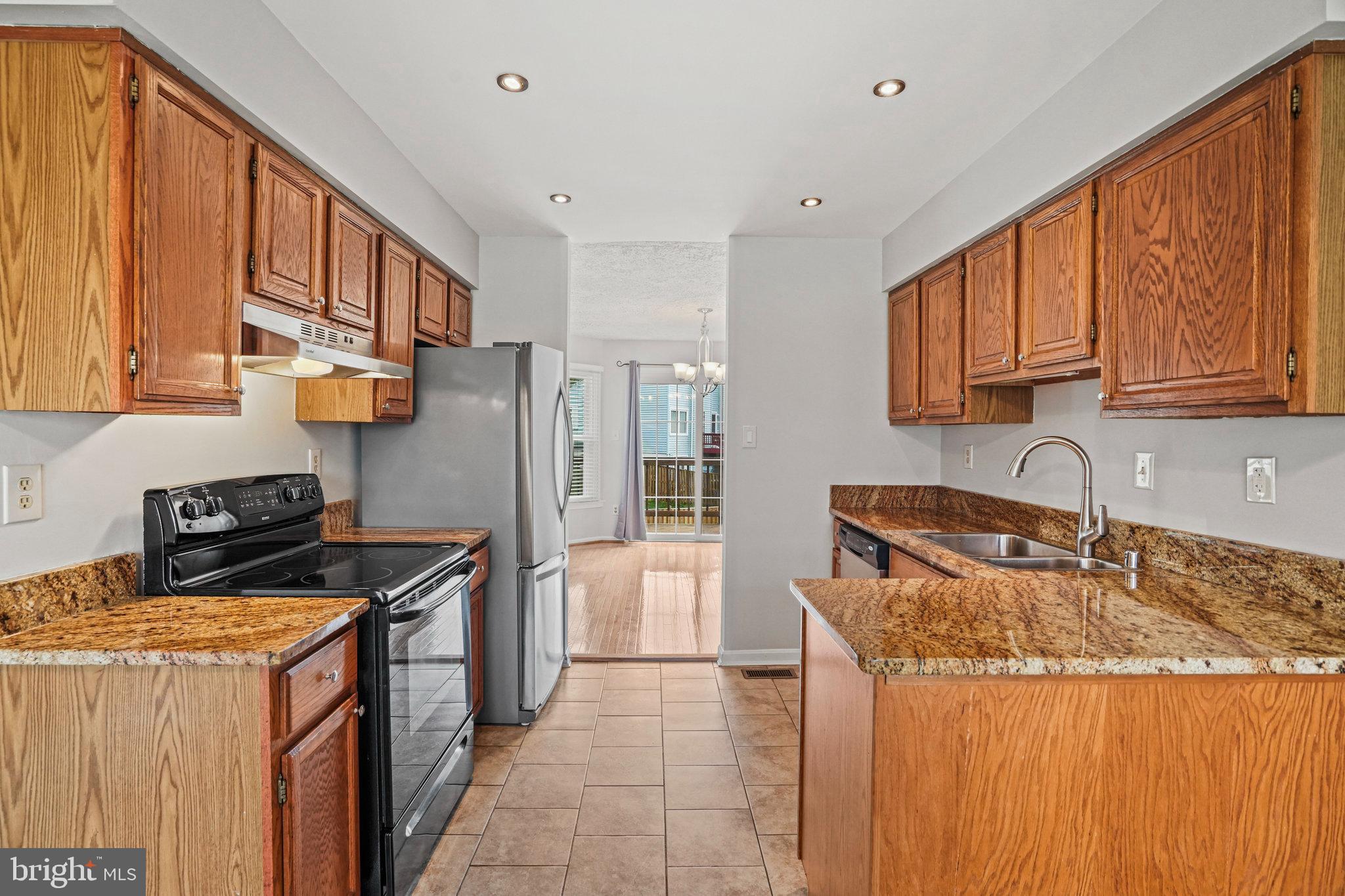 2913 Gracefield Road Silver Spring, MD 20904 - Photo 11 of 53 a kitchen with stainless steel appliances granite countertop a stove a sink dishwasher and a refrigerator with wooden cabinets