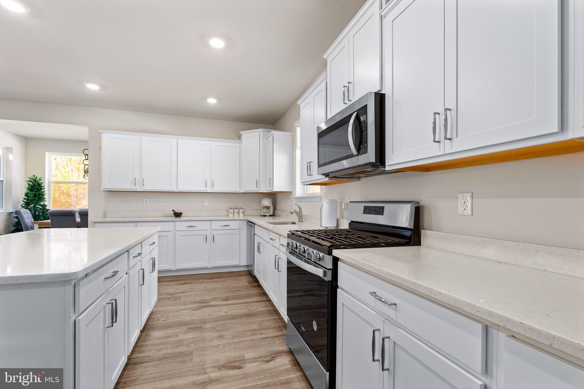 1268 Pimpernell Path Middletown, DE 19709 - Photo 10 of 51 a kitchen with stainless steel appliances granite countertop a sink and dishwasher a stove top oven with wooden floor