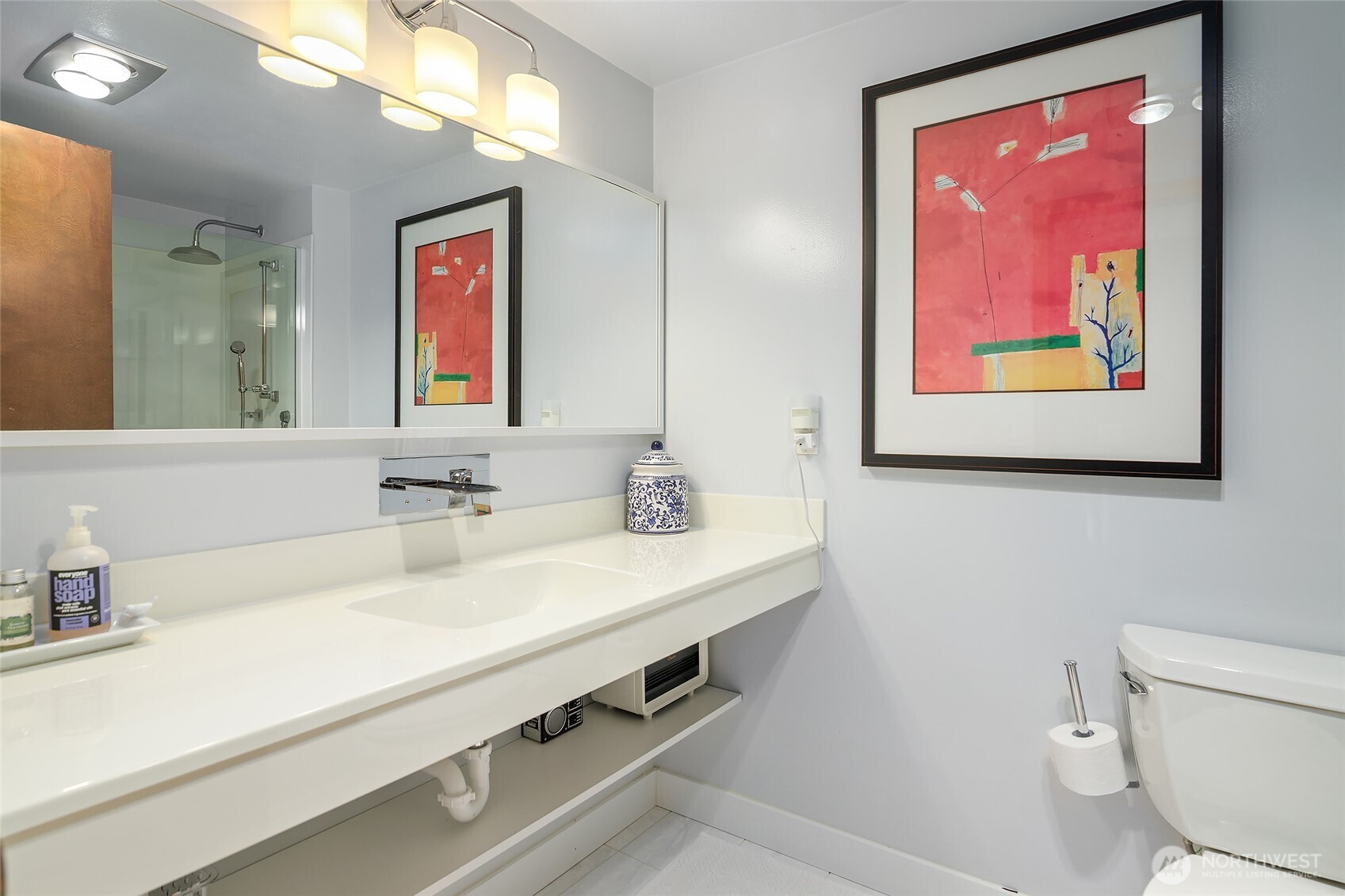 135 North 46th Street, Unit 101 Seattle, WA 98103 - Photo 17 of 30 a bathroom with a sink a mirror and a toilet