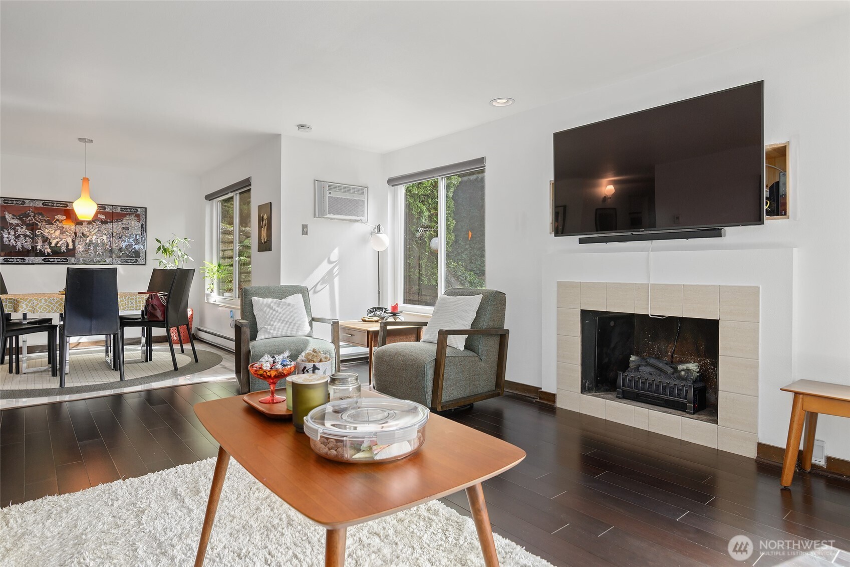 135 North 46th Street, Unit 101 Seattle, WA 98103 - Photo 3 of 30 a living room with furniture a flat screen tv and a fireplace