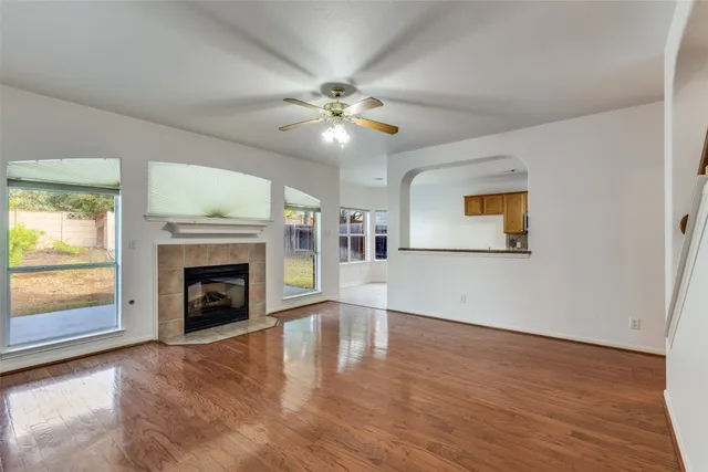wooden floor fireplace and windows in an empty room