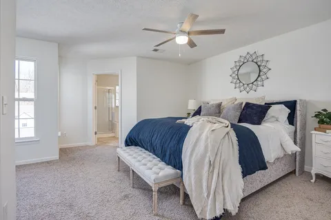 a bedroom with a bed a window and a chandelier