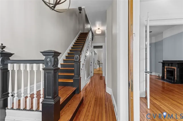 a view of a hallway with wooden floor and staircase