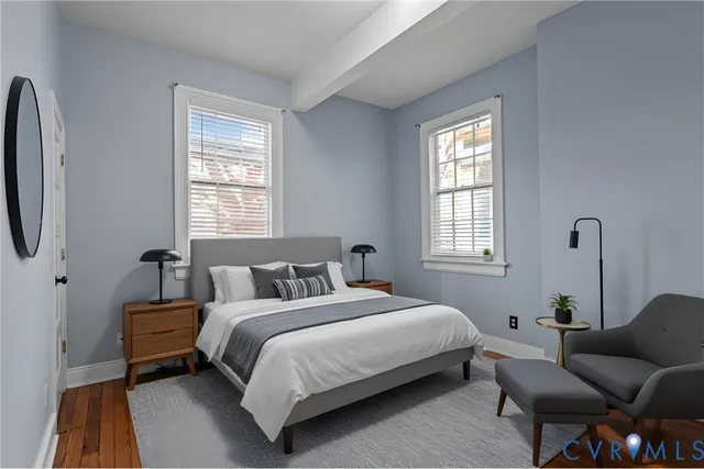 a bedroom with a bed a couch and windows