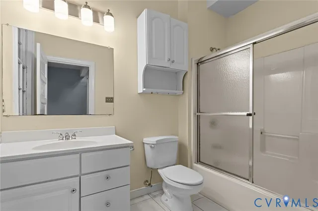 a bathroom with a shower sink vanity mirror and toilet