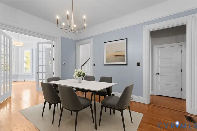 a view of a dining room with furniture a chandelier and wooden floor