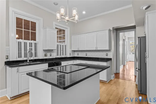 a kitchen that has a sink and a stove with white countertops
