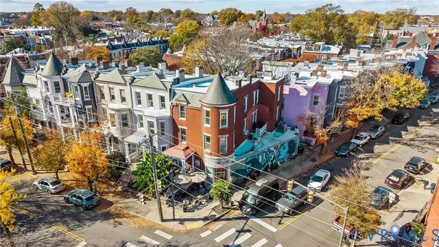 an aerial view of residential houses with outdoor space and parking