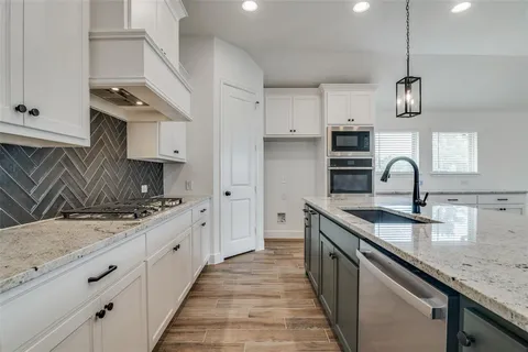 a kitchen with stainless steel appliances granite countertop a sink stove and cabinets