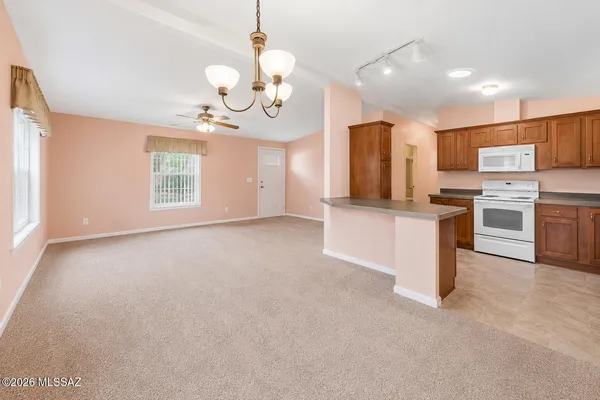 a view of a kitchen with a sink and dishwasher a refrigerator with wooden floor