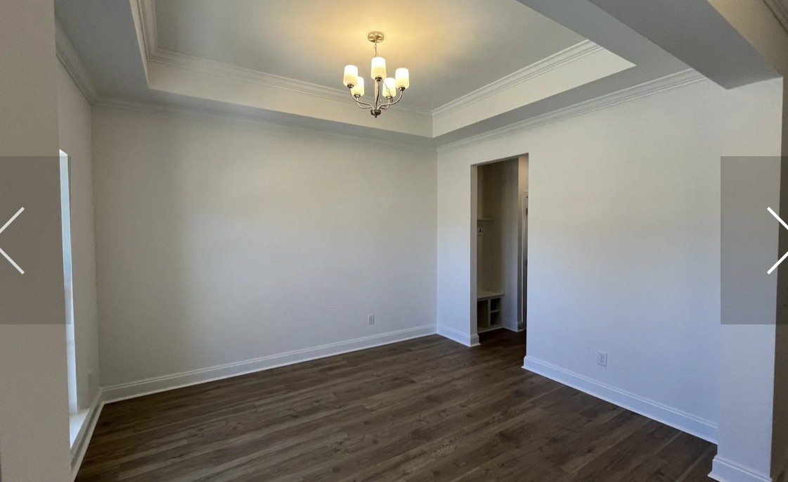 6158 Worthington Road Columbia, TN 38401 - Photo 15 of 48 an empty room with wooden floor and chandelier