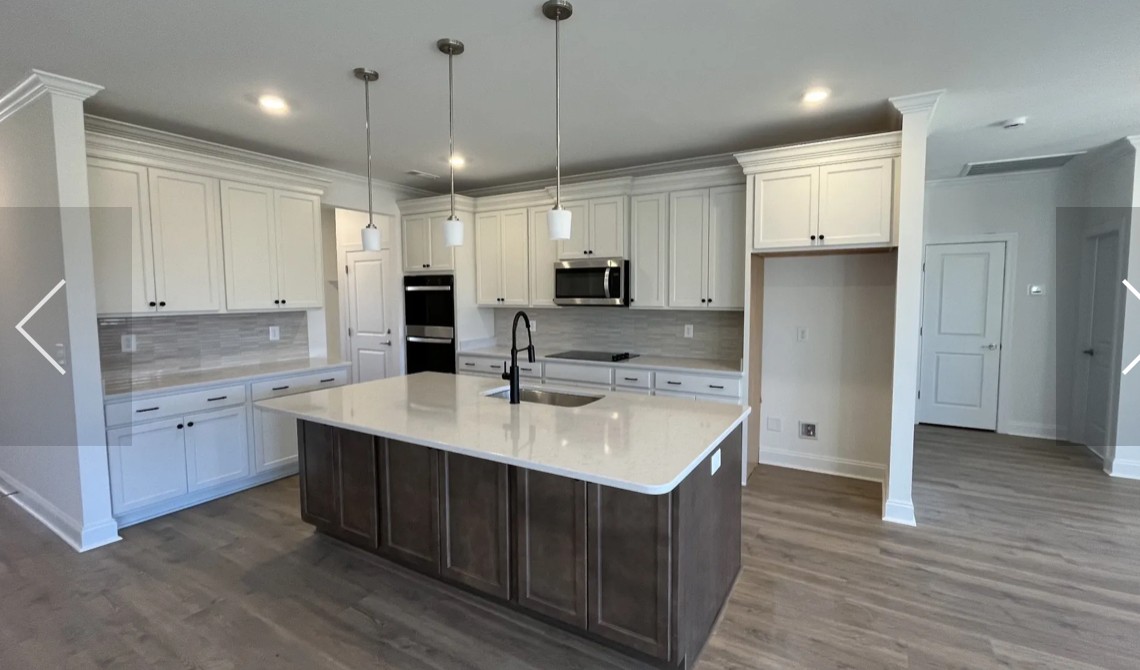 6158 Worthington Road Columbia, TN 38401 - Photo 7 of 48 a kitchen with kitchen island granite countertop a sink cabinets and wooden floor