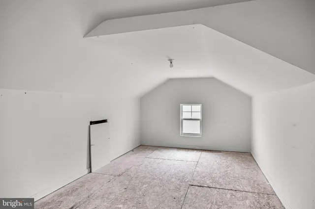 an empty room with a white cabinet and mirror