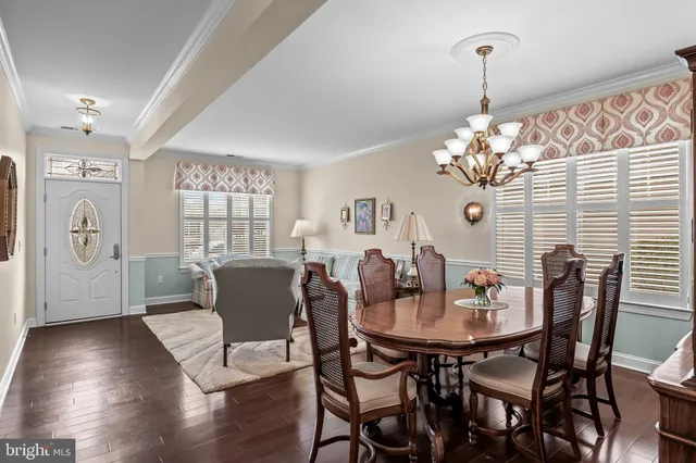 a dining room with furniture a chandelier and wooden floor