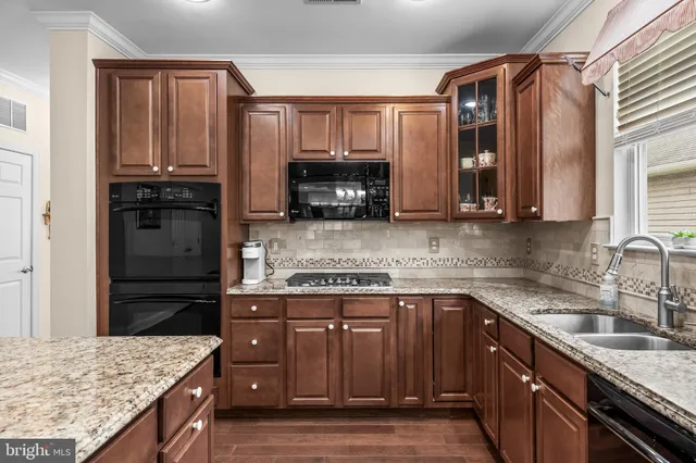 a kitchen with granite countertop a stove top oven microwave and refrigerator