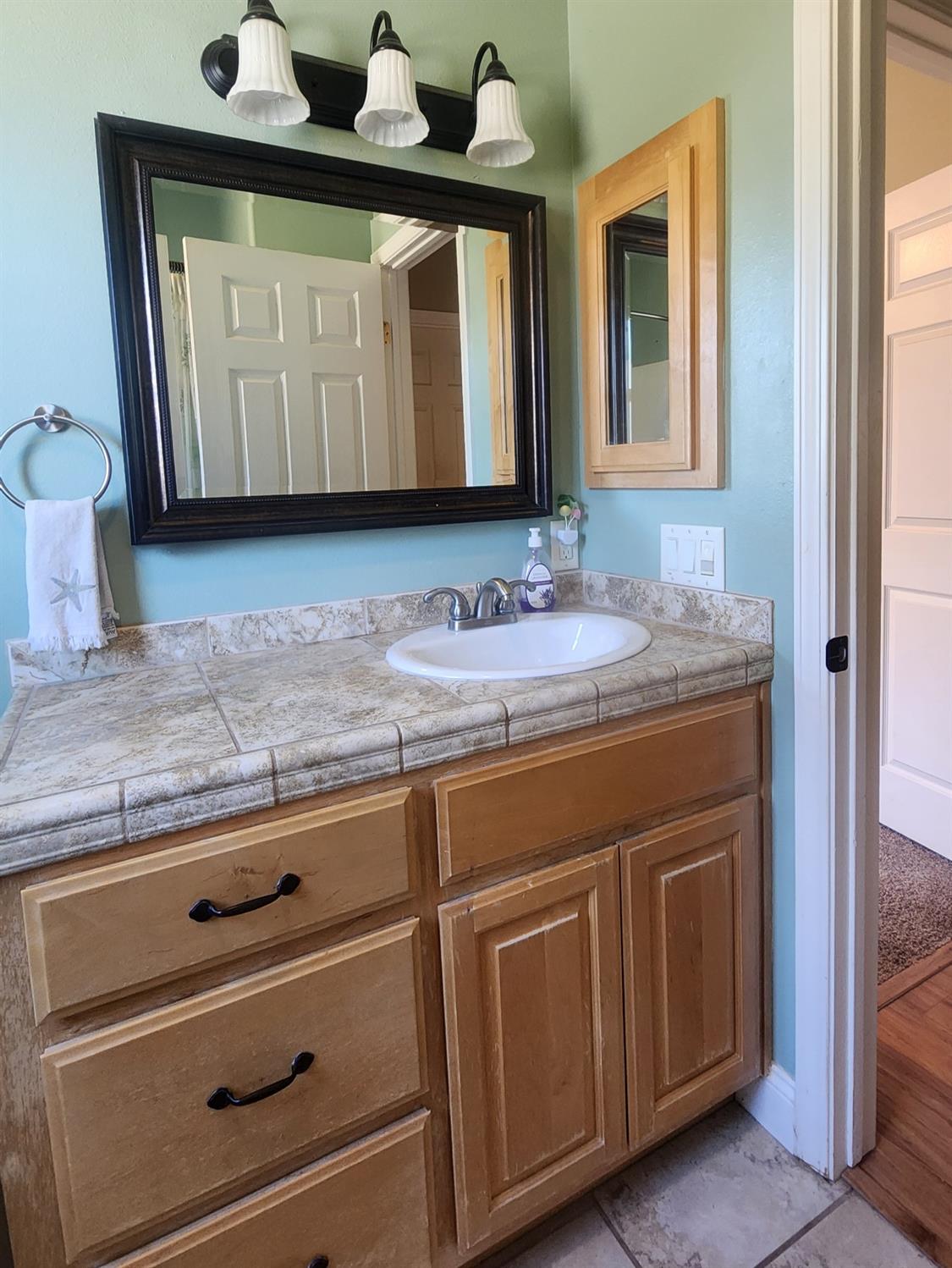 3109 Dunn Road Valley Springs, CA 95252 - Photo 34 of 62 a bathroom with a granite countertop sink and a mirror