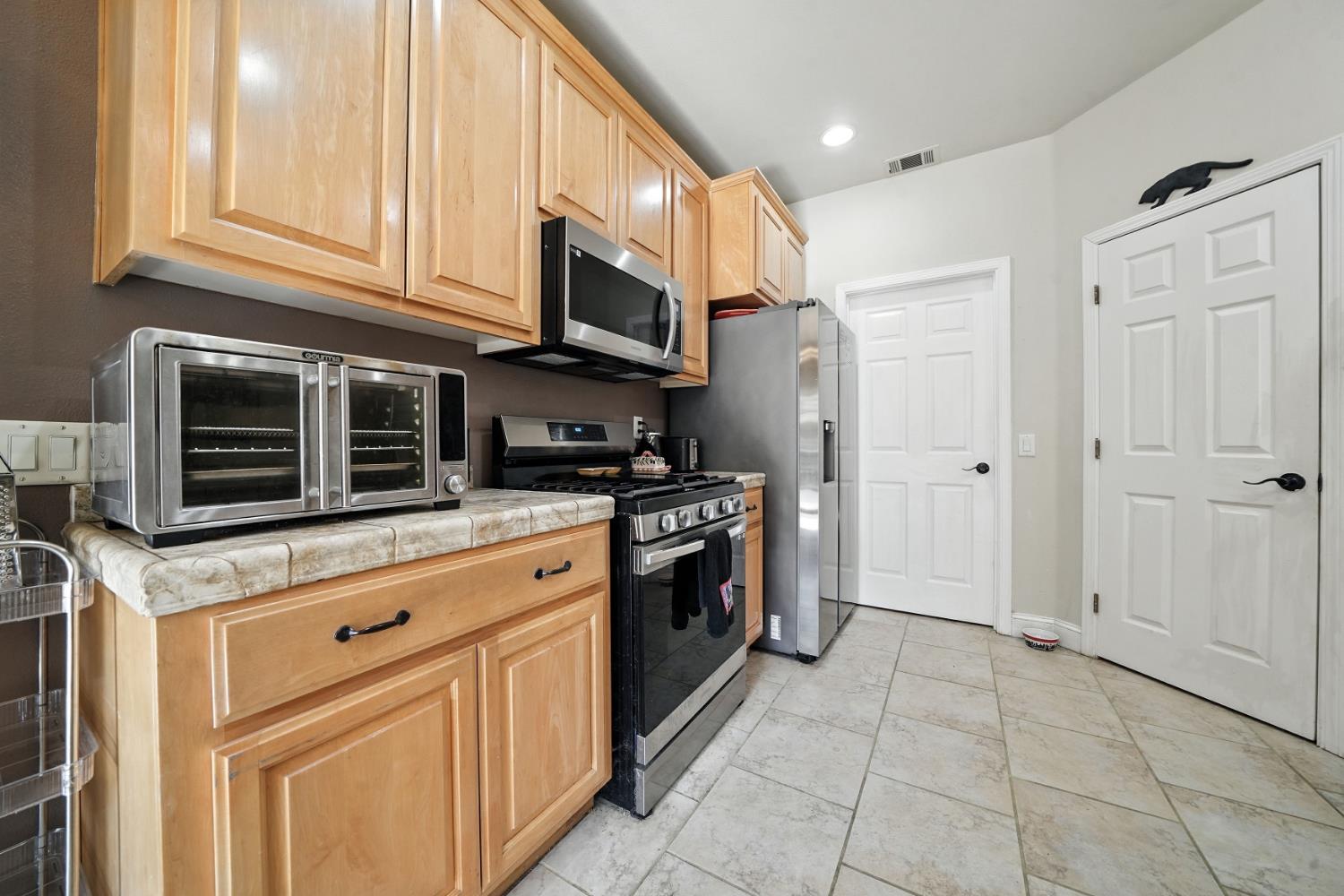 3109 Dunn Road Valley Springs, CA 95252 - Photo 58 of 62 a kitchen with stainless steel appliances granite countertop a stove top oven a refrigerator and cabinets