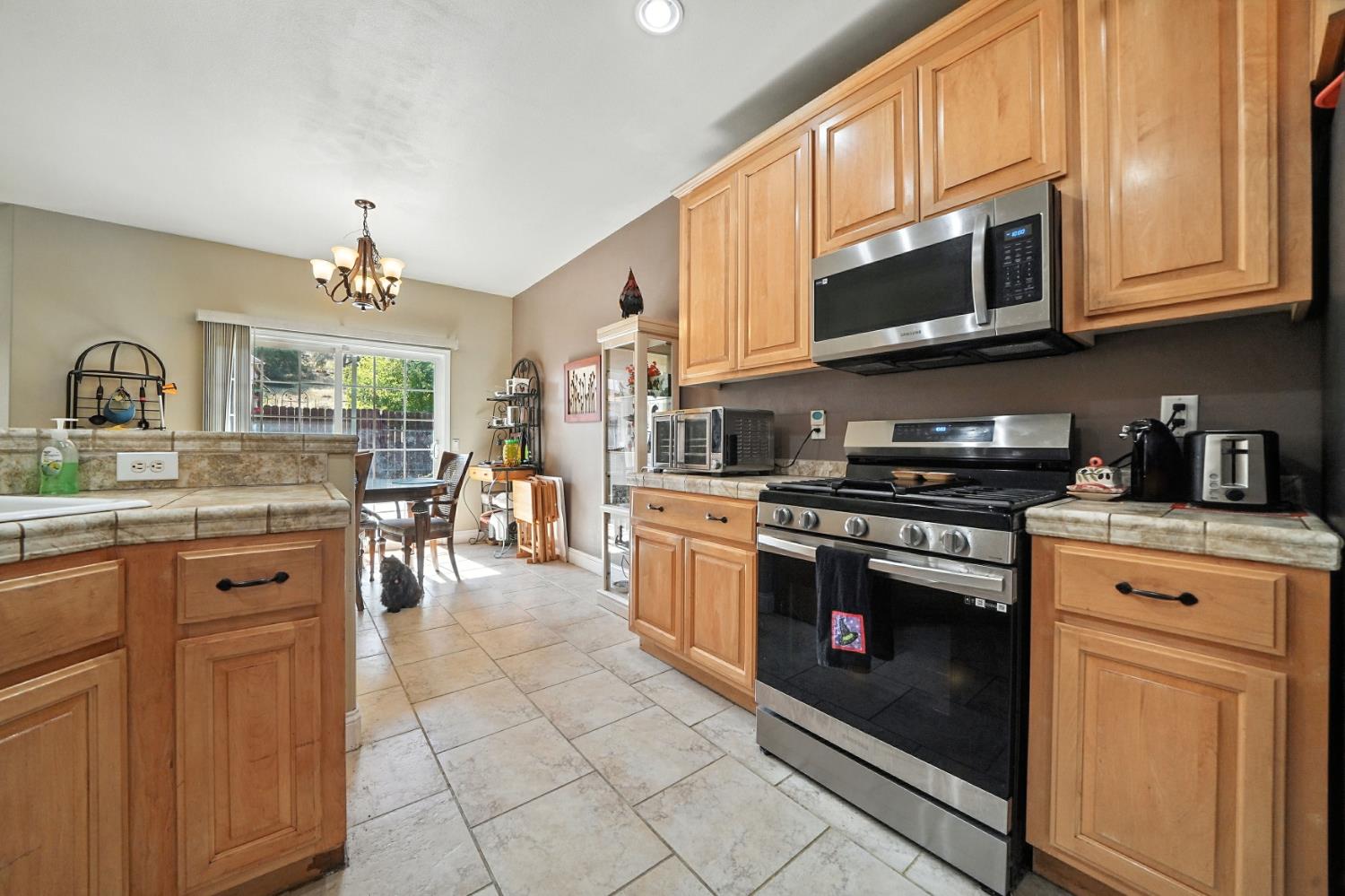 3109 Dunn Road Valley Springs, CA 95252 - Photo 60 of 62 a kitchen with stainless steel appliances granite countertop a stove top oven a sink dishwasher and a microwave oven with white cabinets