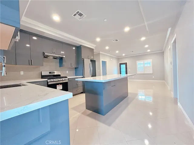 a large kitchen with stainless steel appliances lots of counter top space