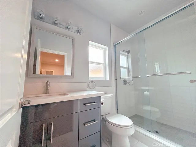 a bathroom with a toilet sink a mirror and shower