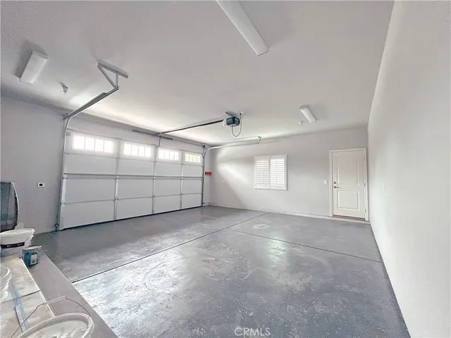 an empty room with windows and cabinet