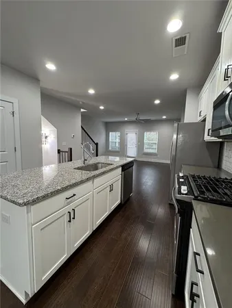 a kitchen with stainless steel appliances granite countertop a stove a sink and a refrigerator