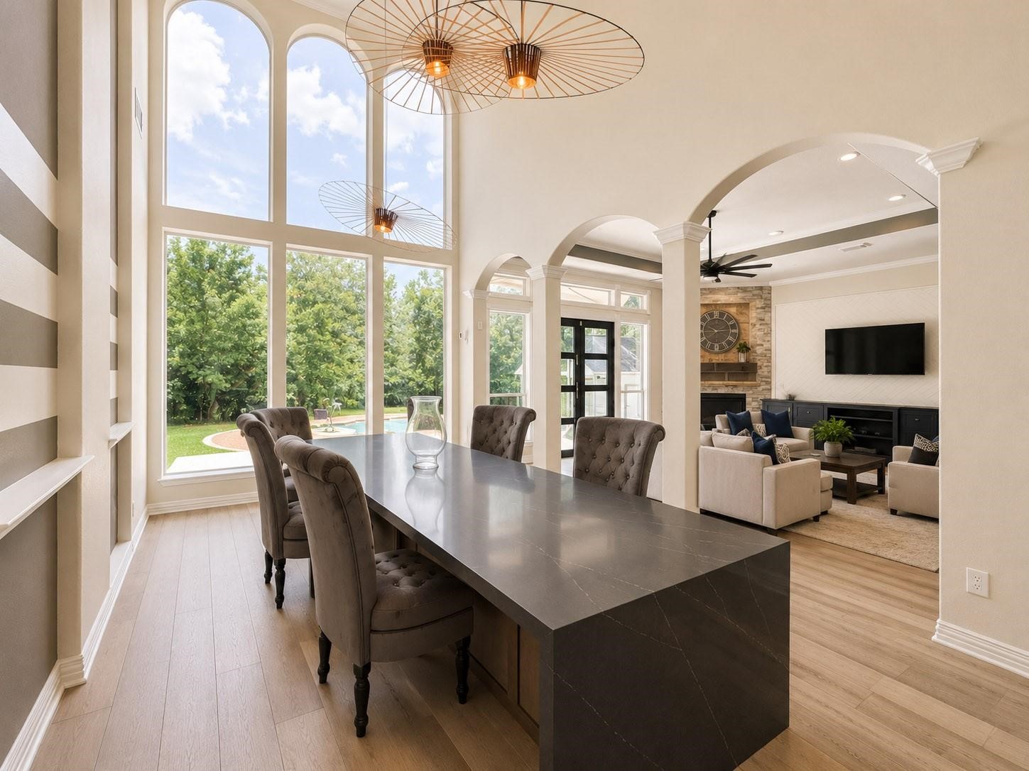 1810 Woerner Road Houston, TX 77090 - Photo 17 of 39 This spacious home features a modern dining area with large arched windows offering abundant natural light and views of the greenery outside. Adjacent is a cozy living area with elegant furnishings and a fireplace, perfect for entertaining or relaxing.