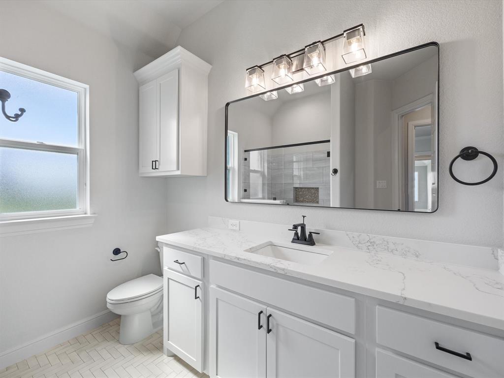 161 Frontera Drive Decatur, TX 76234 - Photo 19 of 40 a bathroom with a toilet sink a mirror and vanity