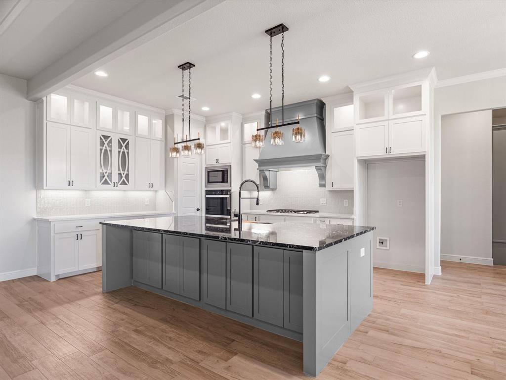 161 Frontera Drive Decatur, TX 76234 - Photo 33 of 40 a kitchen with granite countertop a sink a counter space appliances and cabinets