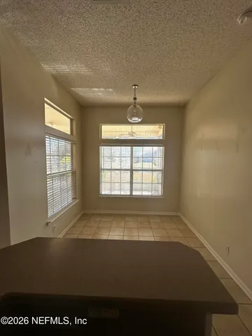 a view of an empty room with wooden floor and a fireplace