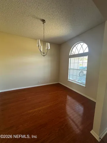 en empty room with windows and ceiling fan