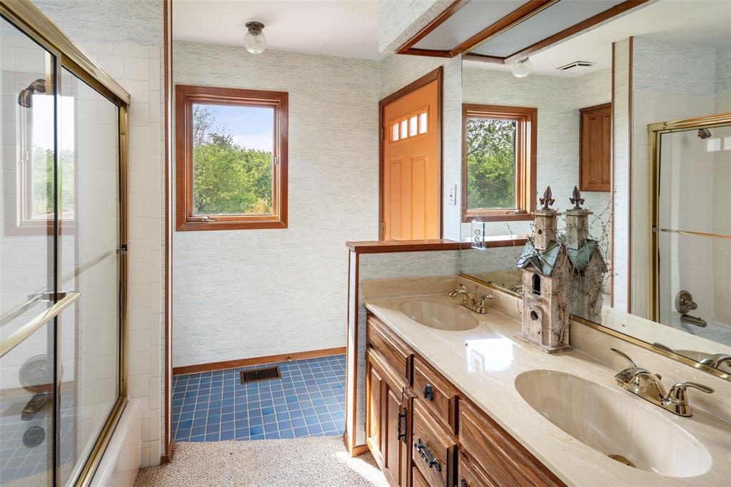 1251 Jim Cannon Road Van Alstyne, TX 75495 - Photo 12 of 31 a bathroom with a granite countertop sink a mirror and a shower