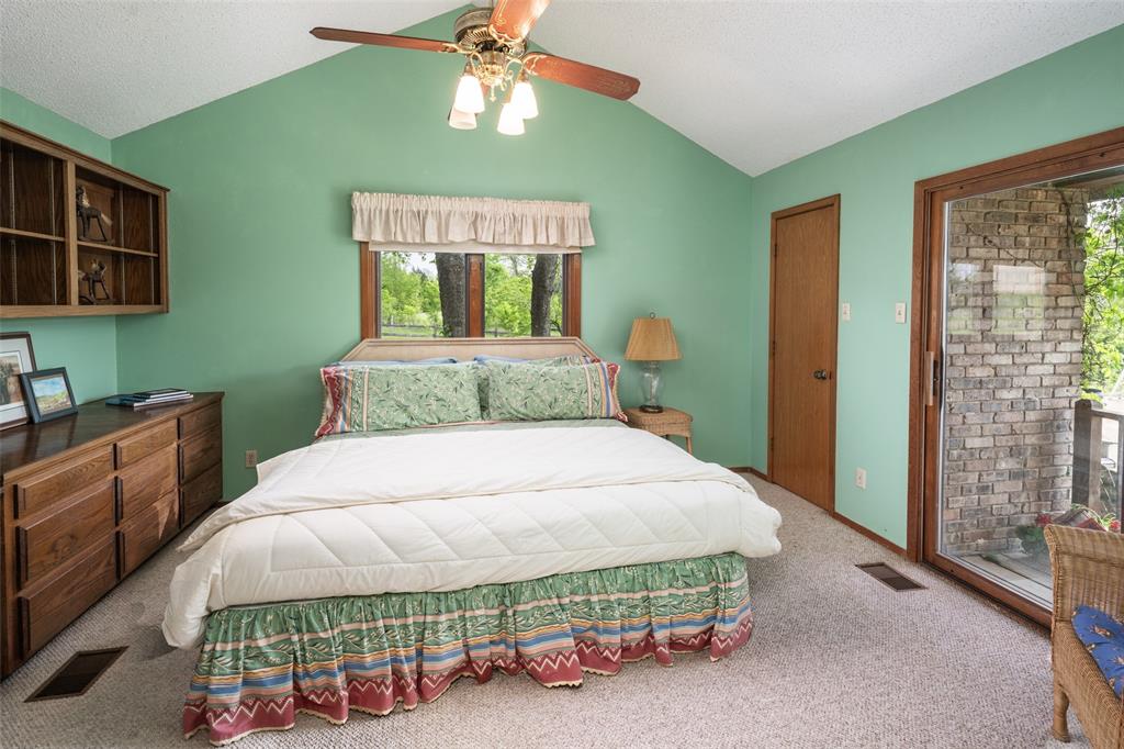 1251 Jim Cannon Road Van Alstyne, TX 75495 - Photo 14 of 31 a bedroom with a bed and a chandelier