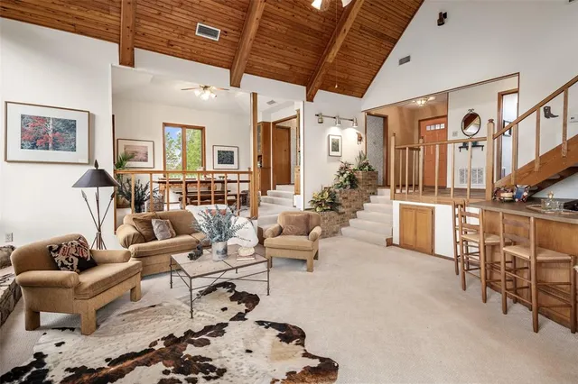 a living room with furniture a flat screen tv and a large window