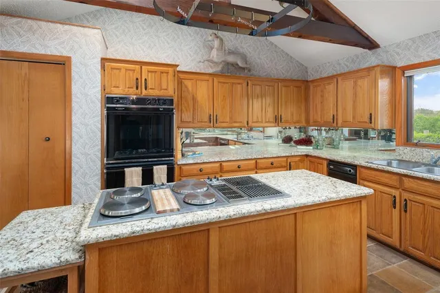 a bathroom with a granite countertop sink a mirror and a shower