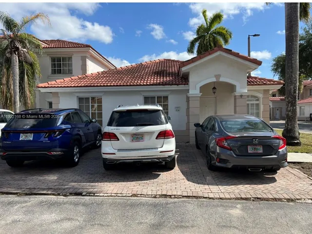 a couple of cars parked in front of a house