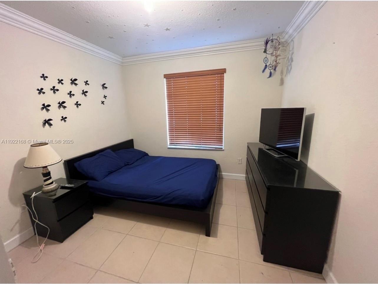 7317 Northwest 173rd Drive, Unit 104 Hialeah, FL 33015 - Photo 11 of 22 a bedroom with a bed and wooden floor