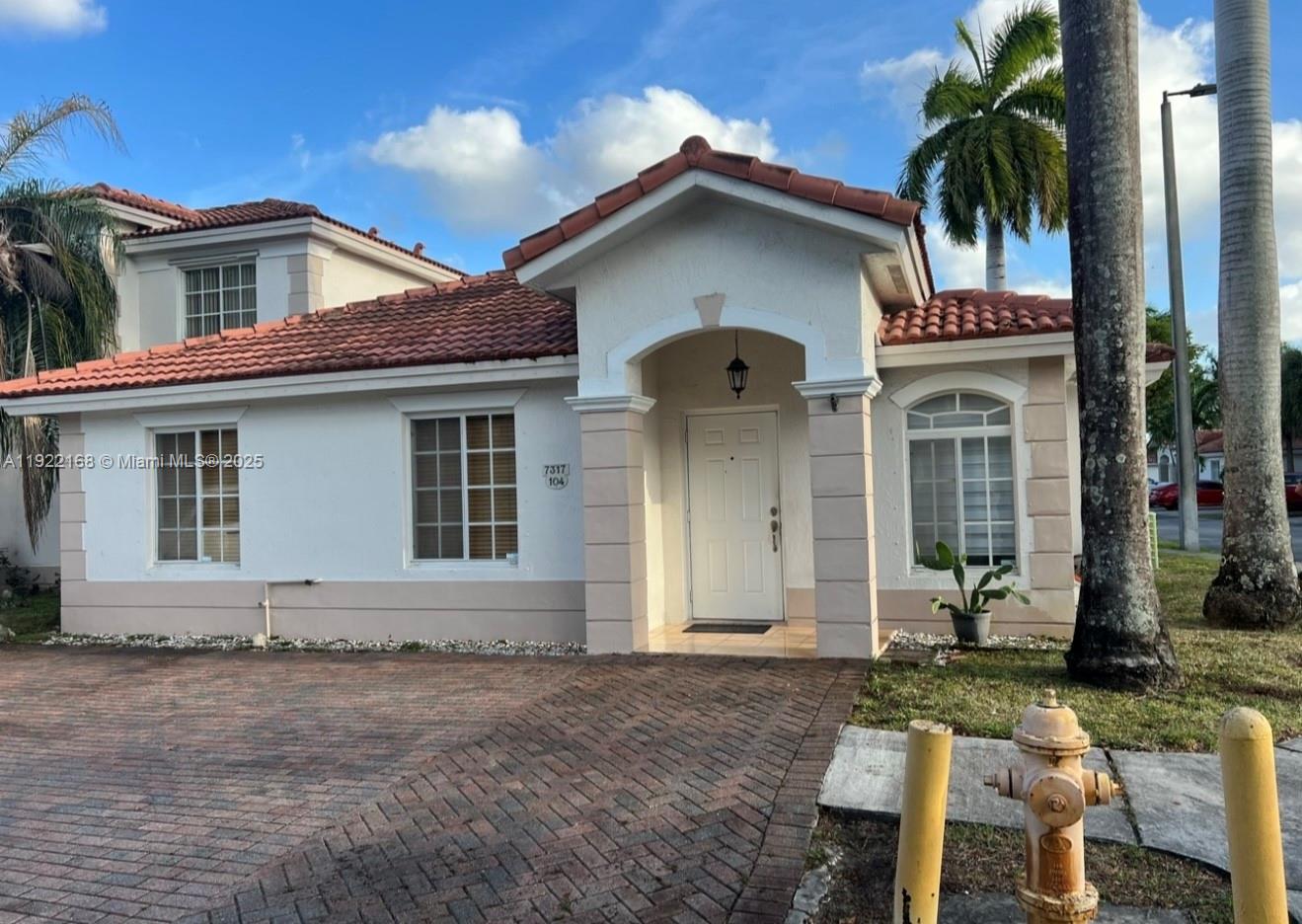 7317 Northwest 173rd Drive, Unit 104 Hialeah, FL 33015 - Photo 16 of 22 a front view of a house with a yard