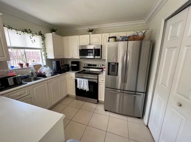 a kitchen with a refrigerator a sink and a stove top oven