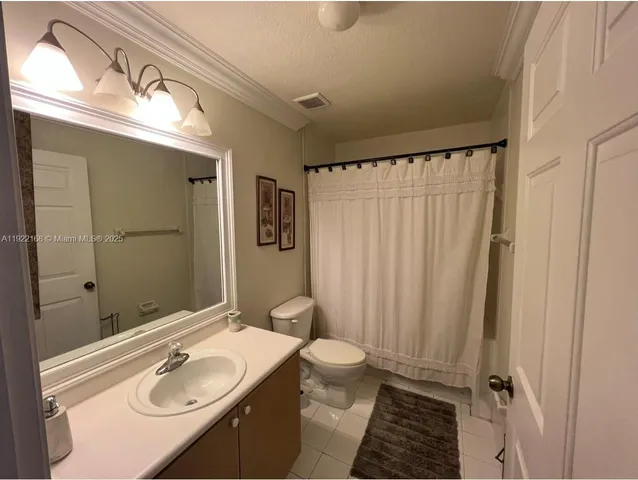 a bathroom with a sink a toilet a mirror and shower