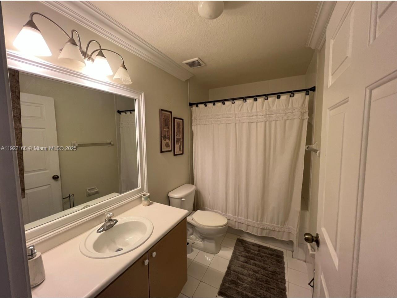 7317 Northwest 173rd Drive, Unit 104 Hialeah, FL 33015 - Photo 10 of 22 a bathroom with a sink a toilet a mirror and shower