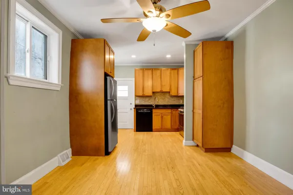 a kitchen with stainless steel appliances granite countertop a refrigerator a oven a sink with wooden floors and cabinets