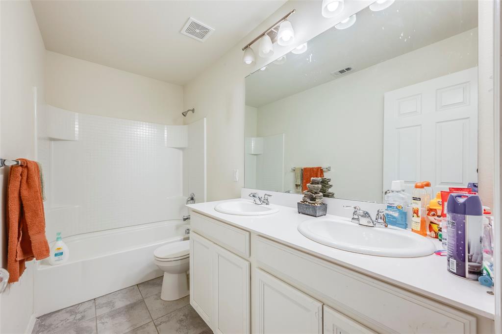 1062 Spofford Drive Forney, TX 75126 - Photo 19 of 23 a bathroom with a sink a toilet and a mirror