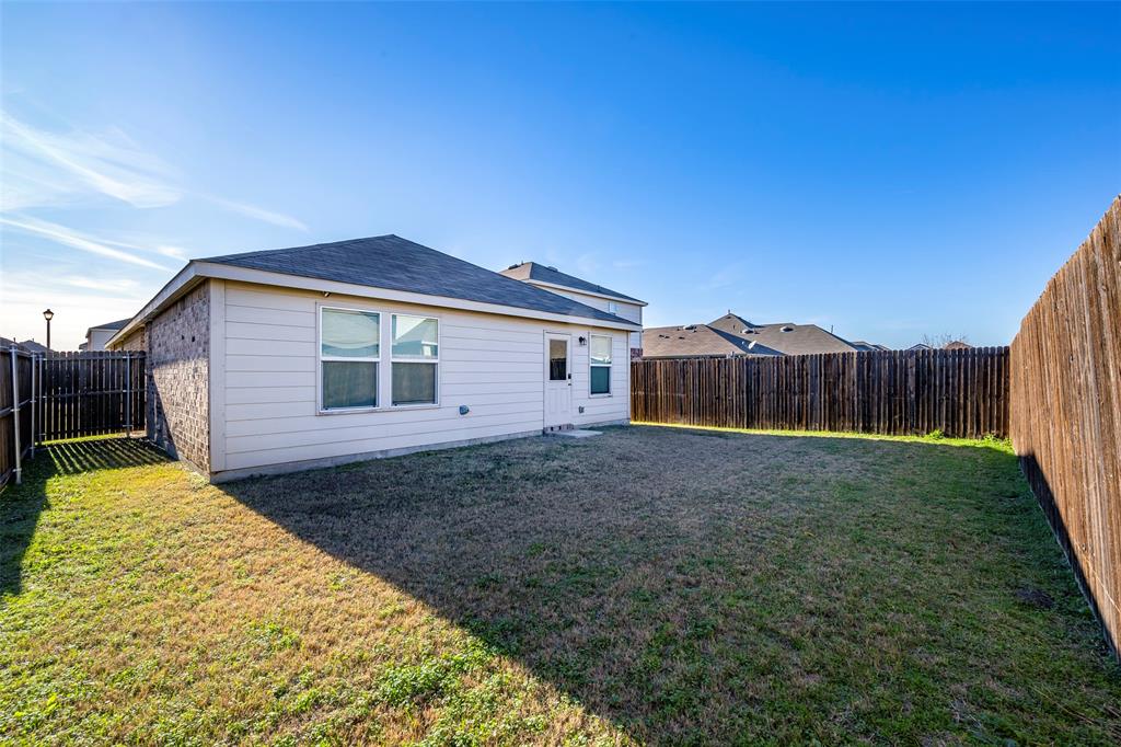 1062 Spofford Drive Forney, TX 75126 - Photo 23 of 23 a view of a backyard with wooden fence