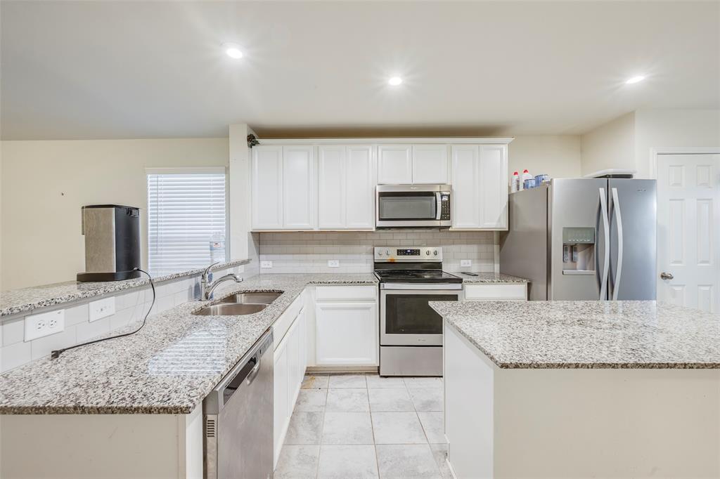 1062 Spofford Drive Forney, TX 75126 - Photo 10 of 23 a kitchen with a sink stove and refrigerator