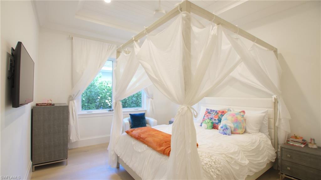 700 Wedge Drive Naples, FL 34103 - Photo 10 of 19 Bedroom with a raised ceiling and light hardwood / wood-style flooring