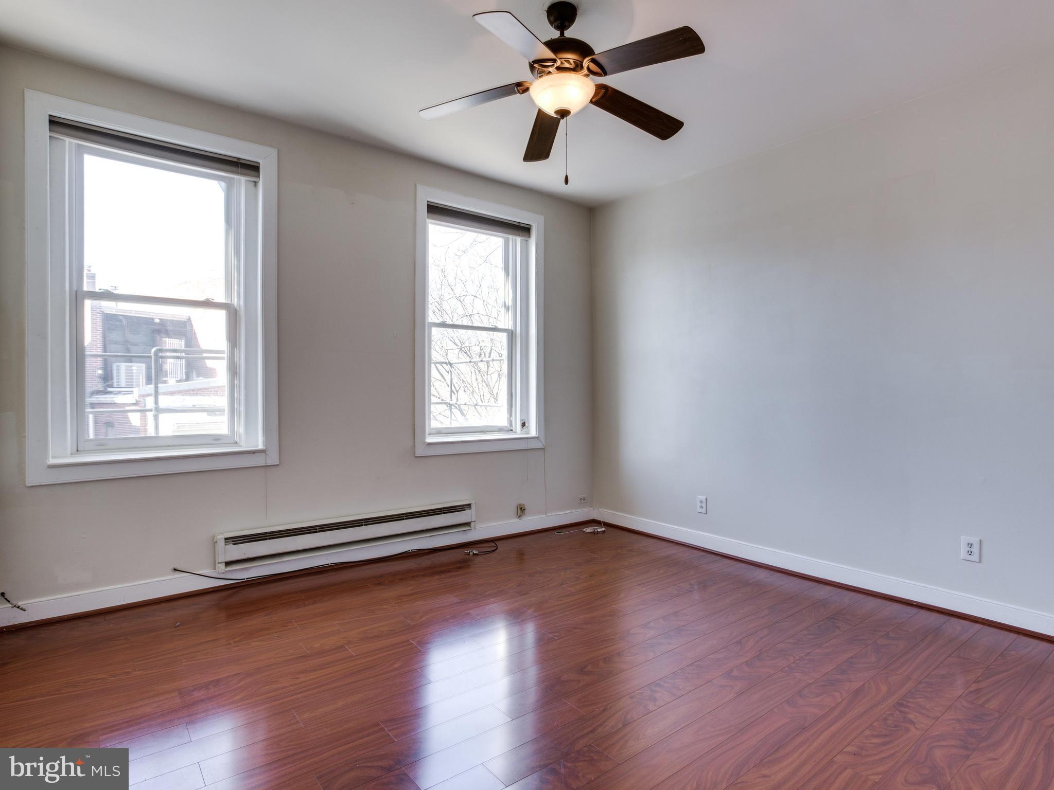 1954 Calvert Street Northwest Washington, DC 20009 - Photo 20 of 28 a view of empty room with wooden floor and fan