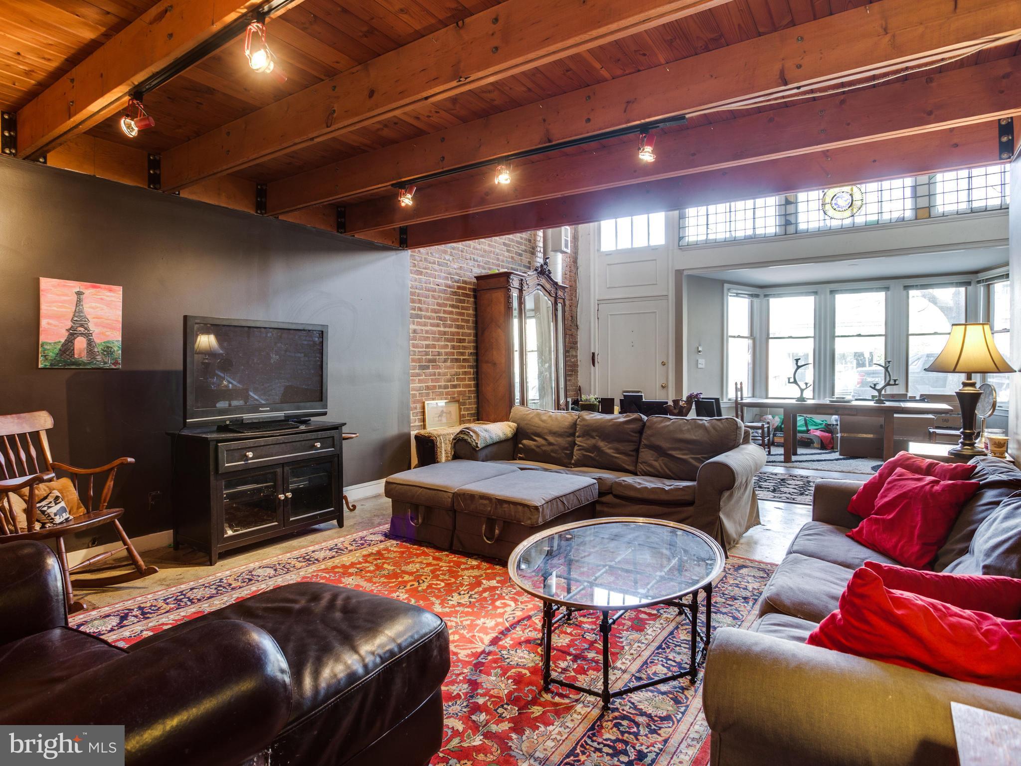 1954 Calvert Street Northwest Washington, DC 20009 - Photo 3 of 28 a living room with furniture and a flat screen tv